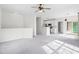 Open-concept living area with plush carpeting, ceiling fan, and a bar overlooking the modern kitchen at 2421 Kudrow Ln, Morrisville, NC 27560