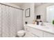 A well-lit bathroom featuring a white vanity, patterned shower curtain, and neutral decor at 25 Cornfield Ln, Benson, NC 27504