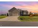Beautiful home featuring manicured lawn, lovely landscaping, and a large driveway under a colorful sunset at 25 Cornfield Ln, Benson, NC 27504