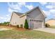 Side angle view of a spacious two-car garage with landscaped surroundings and driveway at 25 Cornfield Ln, Benson, NC 27504