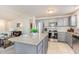 Modern kitchen boasts stainless steel appliances, gray cabinets, granite countertops, and a central island open to the living area at 25 Cornfield Ln, Benson, NC 27504