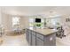 Open-concept kitchen featuring a gray island with granite countertops, seamlessly connected to the dining and living areas at 25 Cornfield Ln, Benson, NC 27504