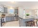 Well-equipped kitchen featuring gray cabinets, granite countertops, stainless steel appliances, and a convenient island with bar stools at 25 Cornfield Ln, Benson, NC 27504