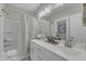 Well-lit bathroom featuring a double sink vanity, shower with curtain, and modern fixtures at 2528 Forge Village Way, Apex, NC 27523