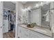 Bright bathroom features double vanity, white cabinets, and walk-in closet at 2528 Forge Village Way, Apex, NC 27523