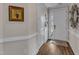 Inviting entryway featuring hardwood floors, white trim, and a stylish front door at 2528 Forge Village Way, Apex, NC 27523