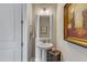 Stylish half bath with a pedestal sink, decorative mirror, and elegant fixtures at 2528 Forge Village Way, Apex, NC 27523