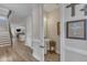 Hallway view featuring hardwood floors, white trim, half bath, and staircase at 2528 Forge Village Way, Apex, NC 27523