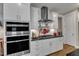 Modern kitchen featuring stainless steel appliances, white cabinetry, and granite countertops at 2528 Forge Village Way, Apex, NC 27523