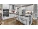Bright kitchen featuring white cabinets, stainless steel appliances, and a sleek center island at 2528 Forge Village Way, Apex, NC 27523