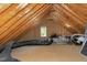 Unfinished attic space with exposed wooden beams, ductwork, and a small window allowing natural light at 2901 Hunters Bluff Dr, Raleigh, NC 27606