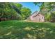 Spacious backyard, features an expansive lawn, mature trees, and partial view of the home's exterior at 2901 Hunters Bluff Dr, Raleigh, NC 27606