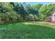 Large, well-maintained backyard offers ample green space bordered by mature trees and landscaping at 2901 Hunters Bluff Dr, Raleigh, NC 27606