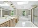 Bathroom featuring double sinks, a soaking tub, walk-in shower and skylight, creating a bright and inviting space at 2901 Hunters Bluff Dr, Raleigh, NC 27606
