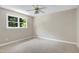 Neutral bedroom with a ceiling fan and a window overlooking lush greenery, offering a tranquil retreat at 2901 Hunters Bluff Dr, Raleigh, NC 27606