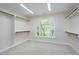 Walk-in closet with carpet, shelving and a window providing natural light for an organized storage space at 2901 Hunters Bluff Dr, Raleigh, NC 27606