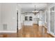 Open concept living room and kitchen features hardwood floors, white cabinets, and stainless steel appliances at 2901 Hunters Bluff Dr, Raleigh, NC 27606