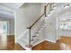Elegant staircase with wooden railing, carpeted treads, and hardwood floors at 2901 Hunters Bluff Dr, Raleigh, NC 27606