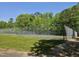 A fenced tennis court, providing a private space for recreational activities amid lush greenery at 2901 Hunters Bluff Dr, Raleigh, NC 27606