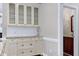 Elegant wet bar area with custom cabinetry, granite countertop, tile backsplash, and decorative glass doors at 2901 Hunters Bluff Dr, Raleigh, NC 27606