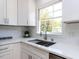 Bright kitchen featuring white quartz countertop, subway tile backsplash, and stainless steel sink at 301 Trappers Sack Rd, Cary, NC 27513