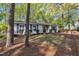 Classic single-story home with blue shutters, nestled among mature trees and natural landscaping at 3116 Henslowe Dr, Raleigh, NC 27603
