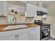 Open kitchen with view into another room, featuring white cabinets and appliances at 3116 Henslowe Dr, Raleigh, NC 27603