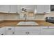 Close-up of kitchen sink and counter area with white cabinets and bronze hardware at 3116 Henslowe Dr, Raleigh, NC 27603