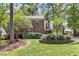 Charming brick home with a landscaped front yard, mature trees, and a welcoming front porch at 3117 Woodgreen Dr, Raleigh, NC 27607