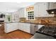 Well-lit kitchen with stainless steel appliances, granite countertops, and wood floors at 3117 Woodgreen Dr, Raleigh, NC 27607