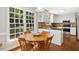 Bright kitchen area with a wood table set with four chairs, large windows, and white cabinets at 3117 Woodgreen Dr, Raleigh, NC 27607