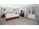 Spacious primary bedroom with a ceiling fan, large windows, and neutral carpet at 3117 Woodgreen Dr, Raleigh, NC 27607