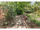Brick pathway leads through lush, landscaped backyard at 3117 Woodgreen Dr, Raleigh, NC 27607