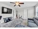Cozy bedroom featuring a ceiling fan, television, and comfortable gray sofa at 312 Loon Ct, Graham, NC 27253