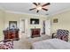 Bright bedroom featuring a ceiling fan and doors to the ensuite bathroom and hall at 312 Loon Ct, Graham, NC 27253