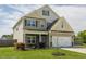 Beautiful two-story home boasts a manicured lawn, complemented by lush landscaping and mature trees at 312 Loon Ct, Graham, NC 27253