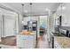 Stylish kitchen featuring granite countertops, stainless steel appliances, white cabinets, and hardwood floors at 312 Loon Ct, Graham, NC 27253