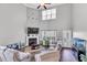 Open-concept living room with a soaring ceiling, a cozy fireplace, and large windows at 312 Loon Ct, Graham, NC 27253