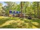 Large backyard with mature trees, covered patio, wood deck, flag pole and manicured lawn at 3312 Shannon Cir, Apex, NC 27539