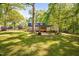 Spacious backyard with mature trees, covered grilling area, swing, and well-maintained lawn at 3312 Shannon Cir, Apex, NC 27539