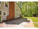 Spacious backyard featuring a brick chimney, concrete patio, mature trees, and storage building at 3312 Shannon Cir, Apex, NC 27539
