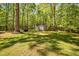 Extensive backyard with mature trees, a storage shed, grilling area, and spacious green lawn at 3312 Shannon Cir, Apex, NC 27539