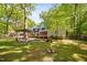 Backyard with mature trees, patio, BBQ area, and screened-in porch, perfect for outdoor entertaining at 3312 Shannon Cir, Apex, NC 27539