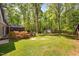 Expansive backyard featuring mature trees, manicured lawn, screened porch, and storage shed at 3312 Shannon Cir, Apex, NC 27539