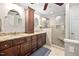 Bathroom with granite vanity, double sinks, a tall cabinet, and a tiled walk-in shower with a bench at 3312 Shannon Cir, Apex, NC 27539