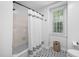 A bright bathroom with a white shower curtain and patterned tile flooring at 3312 Shannon Cir, Apex, NC 27539