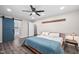 Bright primary bedroom with a ceiling fan, modern furniture, and a sliding blue barn door at 3312 Shannon Cir, Apex, NC 27539