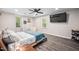 A modern bedroom with a platform bed, ceiling fan, TV, and two windows for natural light at 3312 Shannon Cir, Apex, NC 27539