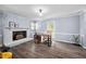 Spacious living room featuring a brick fireplace, modern desk, and hardwood floors at 3312 Shannon Cir, Apex, NC 27539