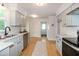Bright kitchen featuring stainless appliances, white cabinets, and a view of the backyard at 3317 E Jameson Rd, Raleigh, NC 27604